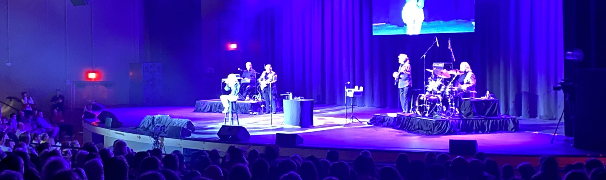 signer on stage in chair washed out by the lights Detroit
